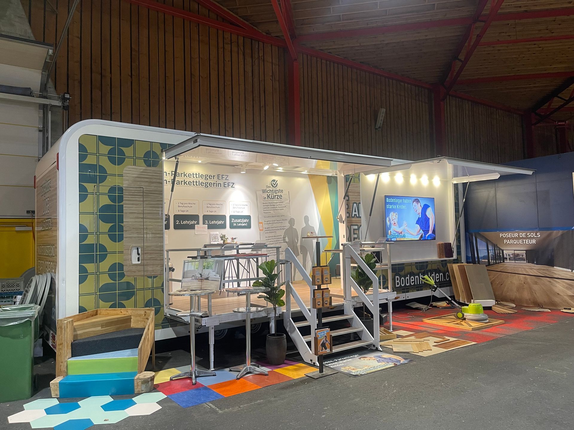 Une remorque est assise dans un entrepôt avec une télévision sur le mur.