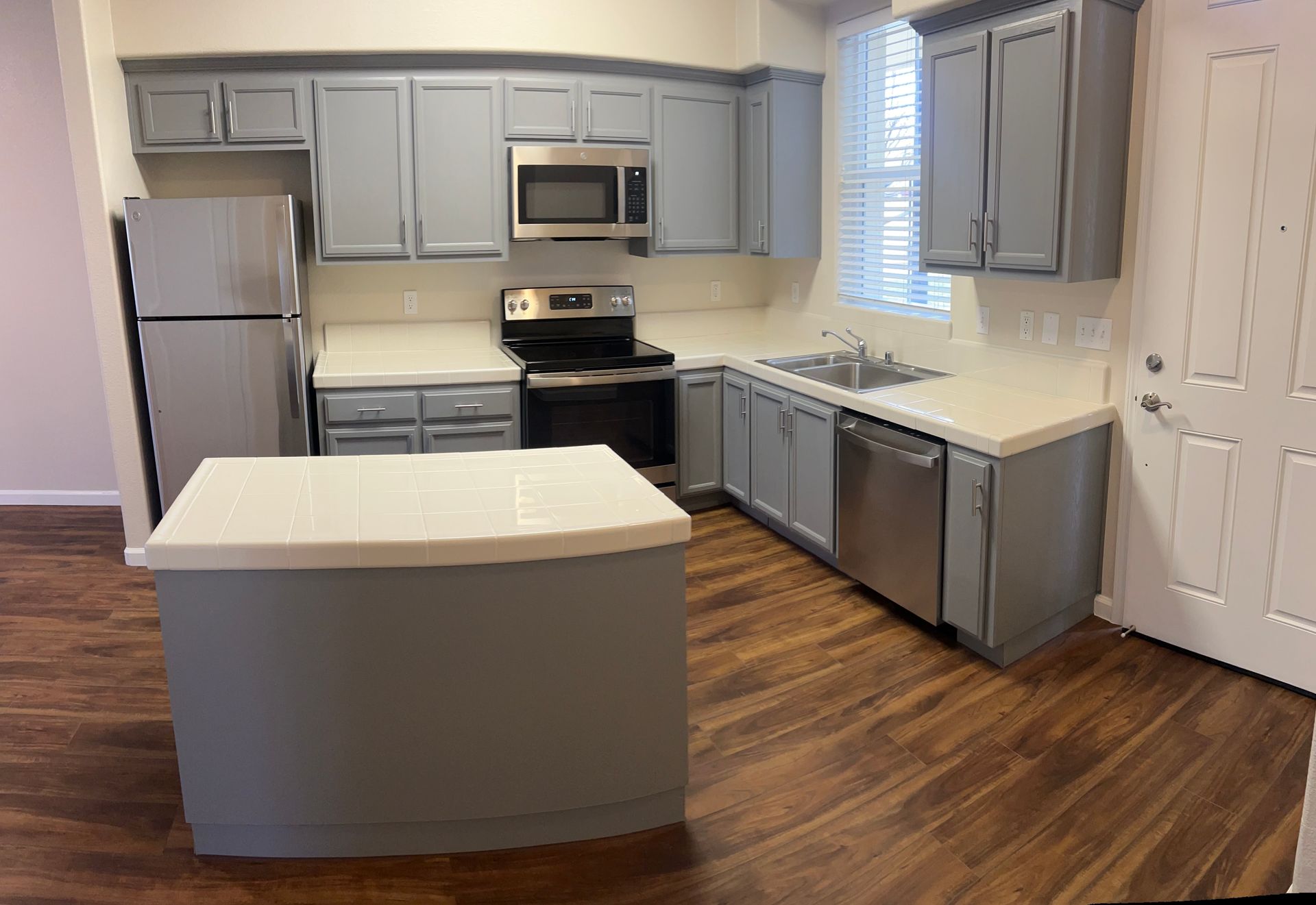 A kitchen with stainless steel appliances and gray cabinets