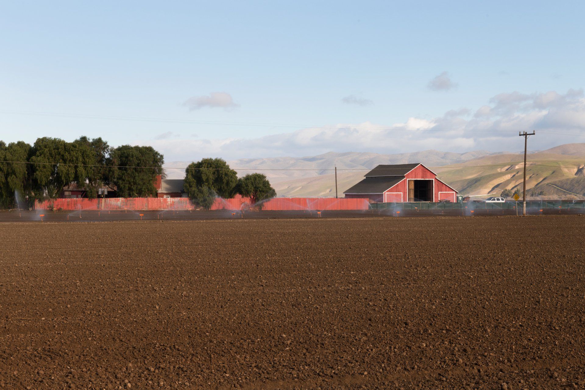 A red barn is sitting in the middle of a field.