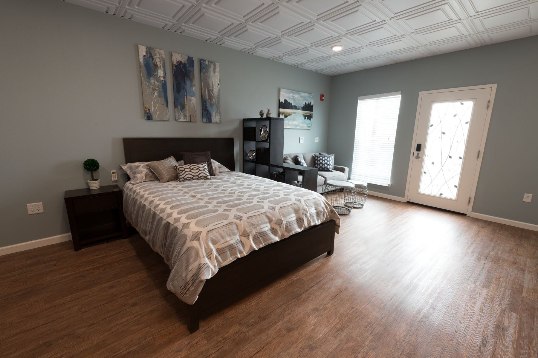A bedroom with hardwood floors and a bed
