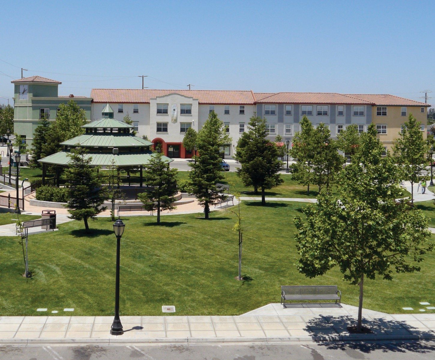 An aerial view of a park with a large building in the background