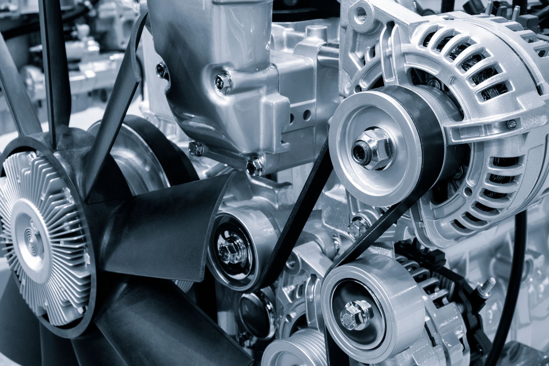 A close up of a car engine with a fan and belts.