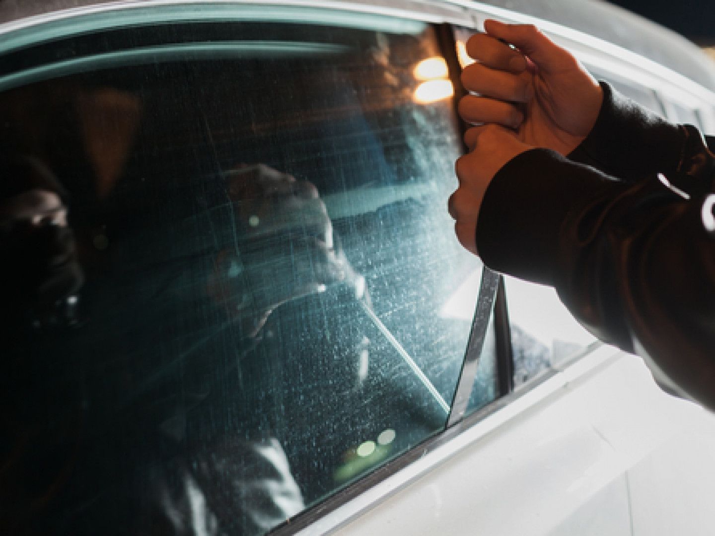 A person is cleaning the windshield of a car.