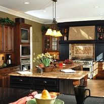 Spacious modern kitchen with wood cabinets, large island, and hanging pendant lights