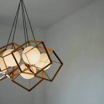 Modern geometric pendant light with white globe bulbs and gold metal frames hanging from the ceiling