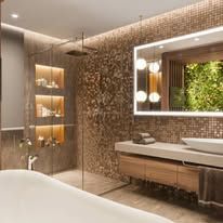 Modern luxury bathroom with walk-in shower, double vanity, warm lighting, and green wall decor