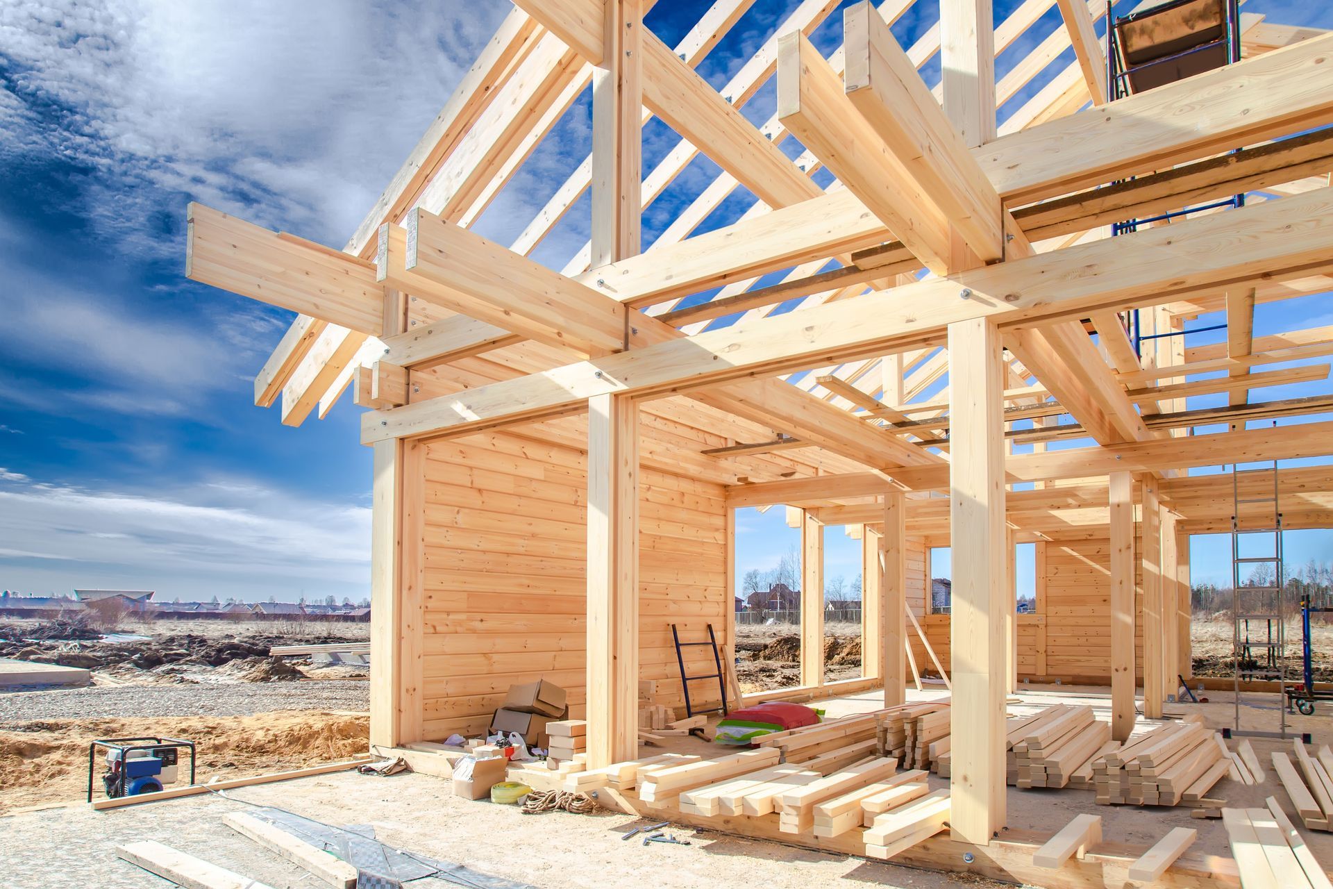 Wood-framed house under construction with exposed beams and blue sky in the background