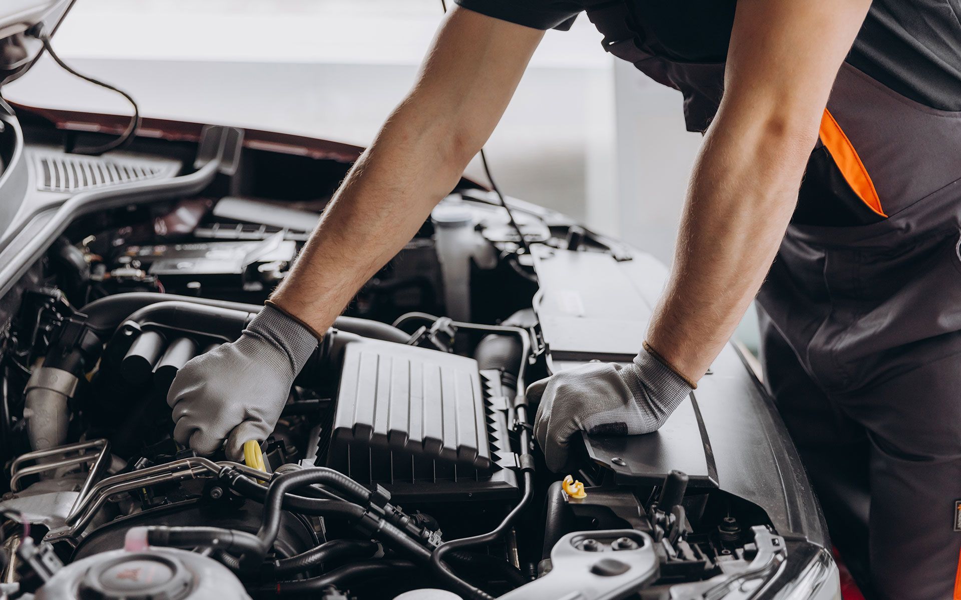 A man is working on the engine of a car.