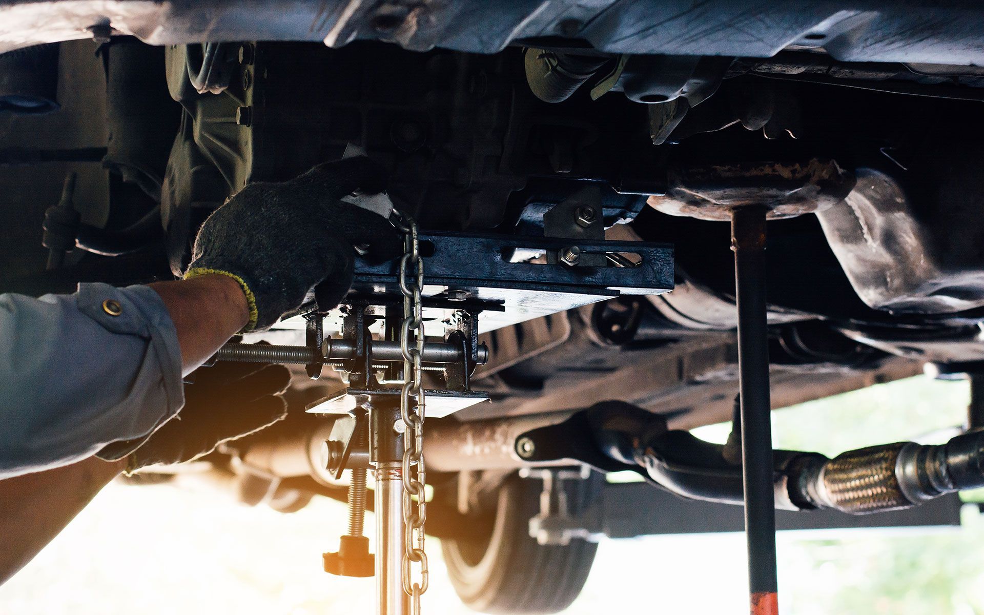 A man is working on the underside of a car.