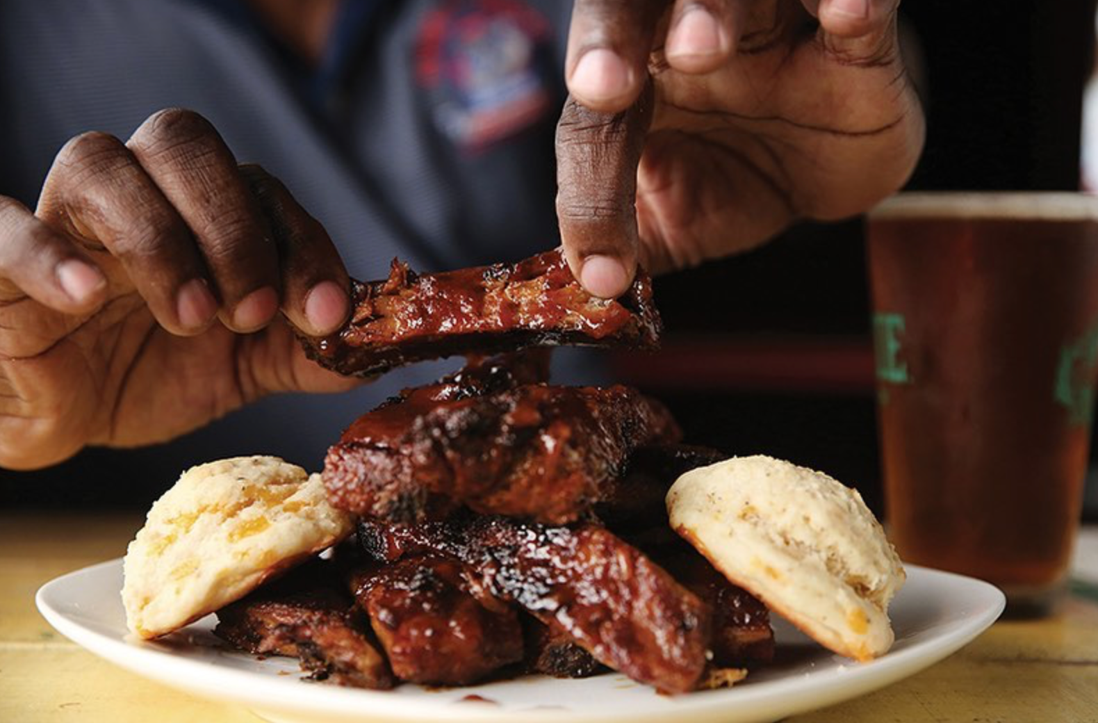 man getting ready to eat bbq ribs and biscuits 