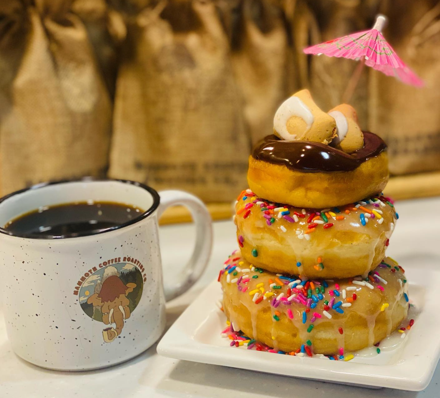 photo of a Mammoth Coffee Roasting Co. mug and donuts stacked high