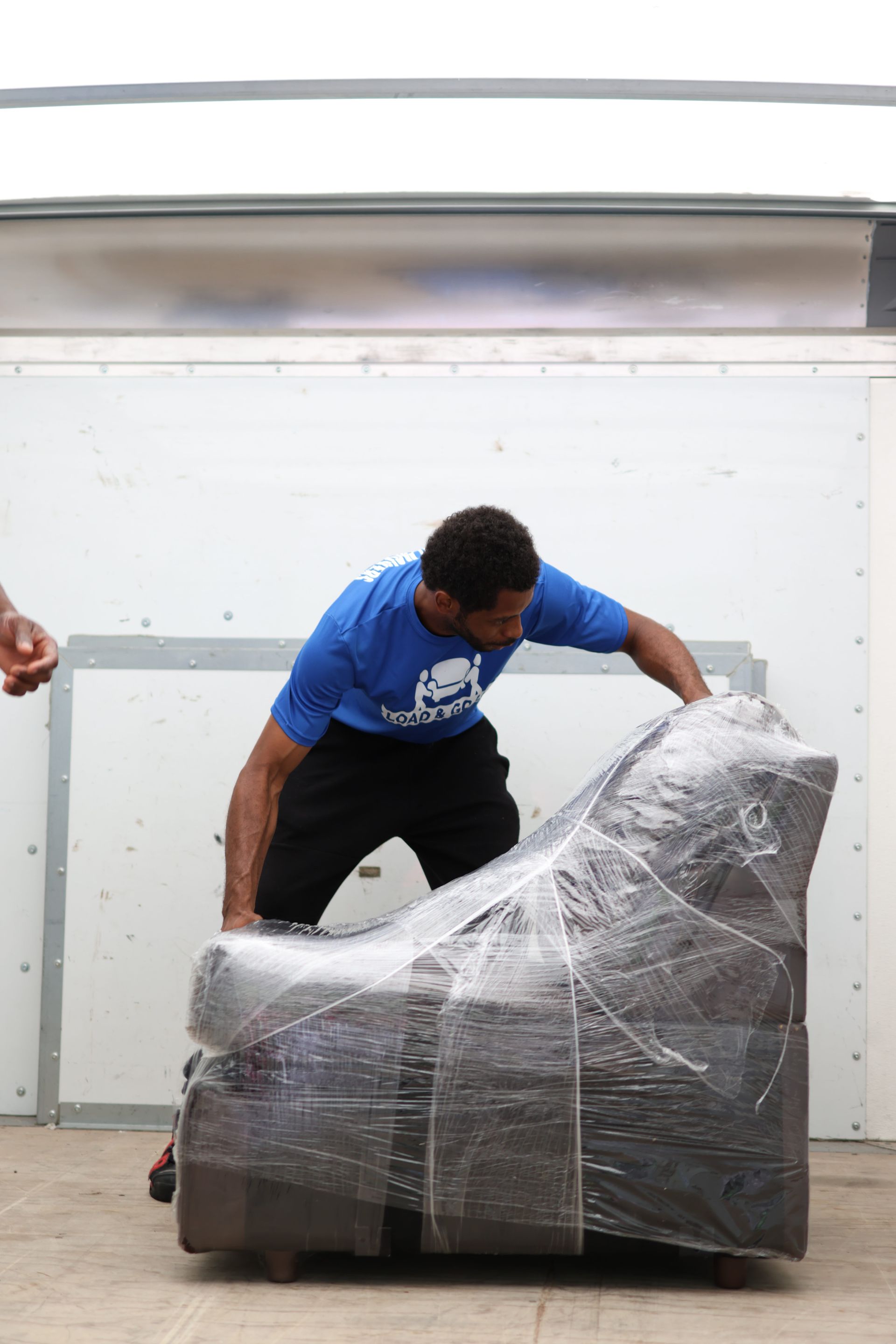 two men are carrying a large item on a dolly in a kitchen .