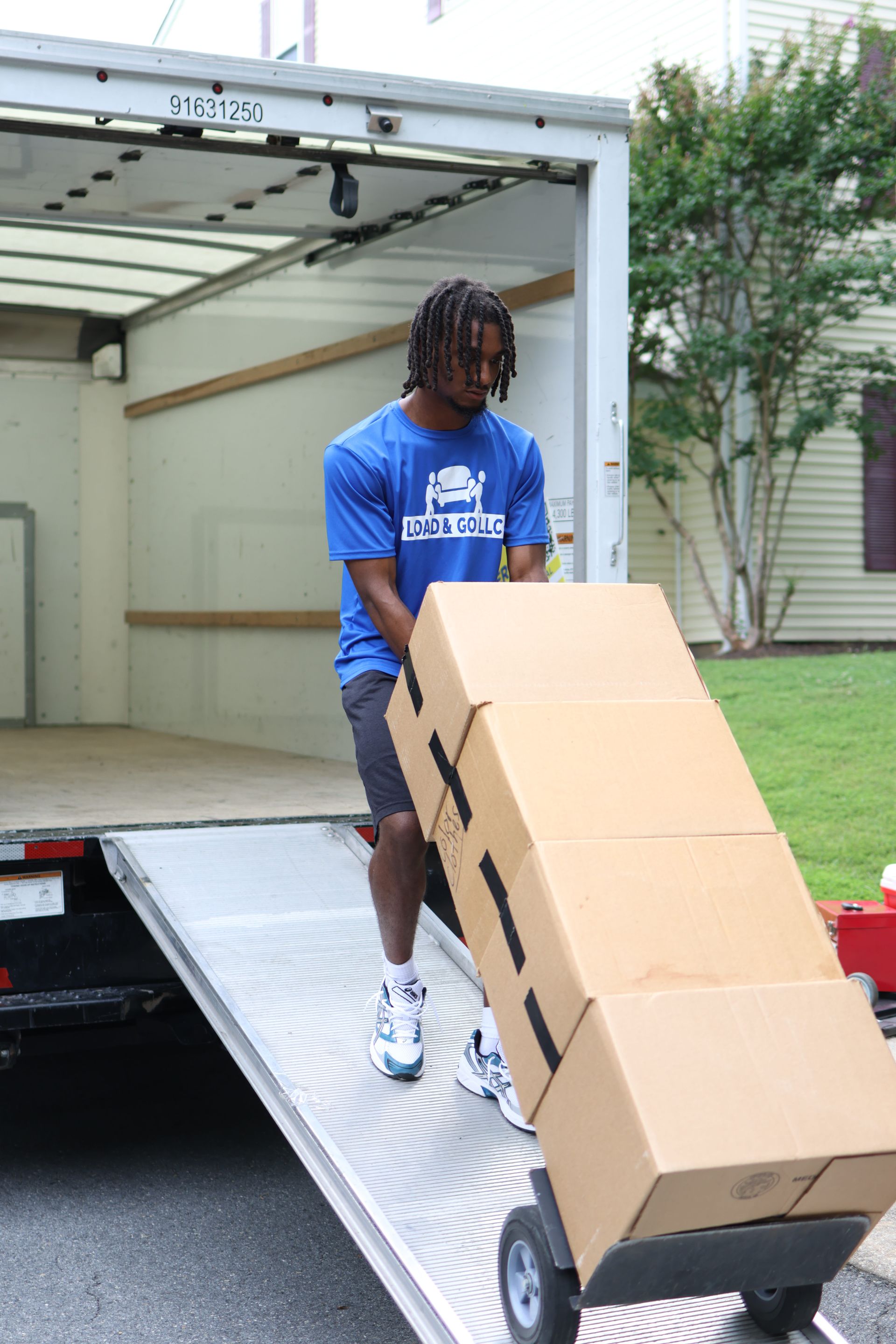 two men are wrapping a couch in plastic wrap in a living room .