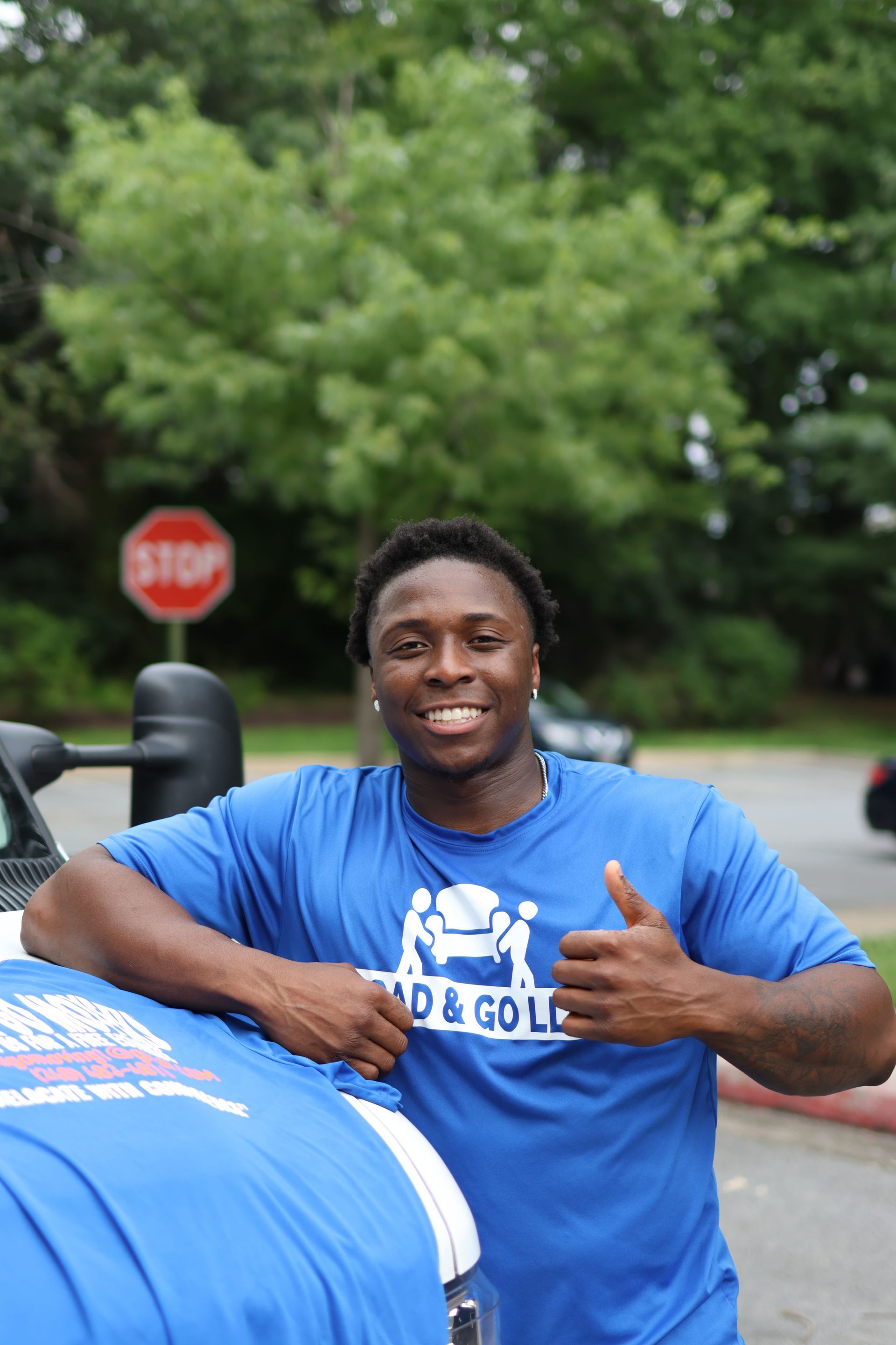 a man and woman are standing in front of a moving truck .
