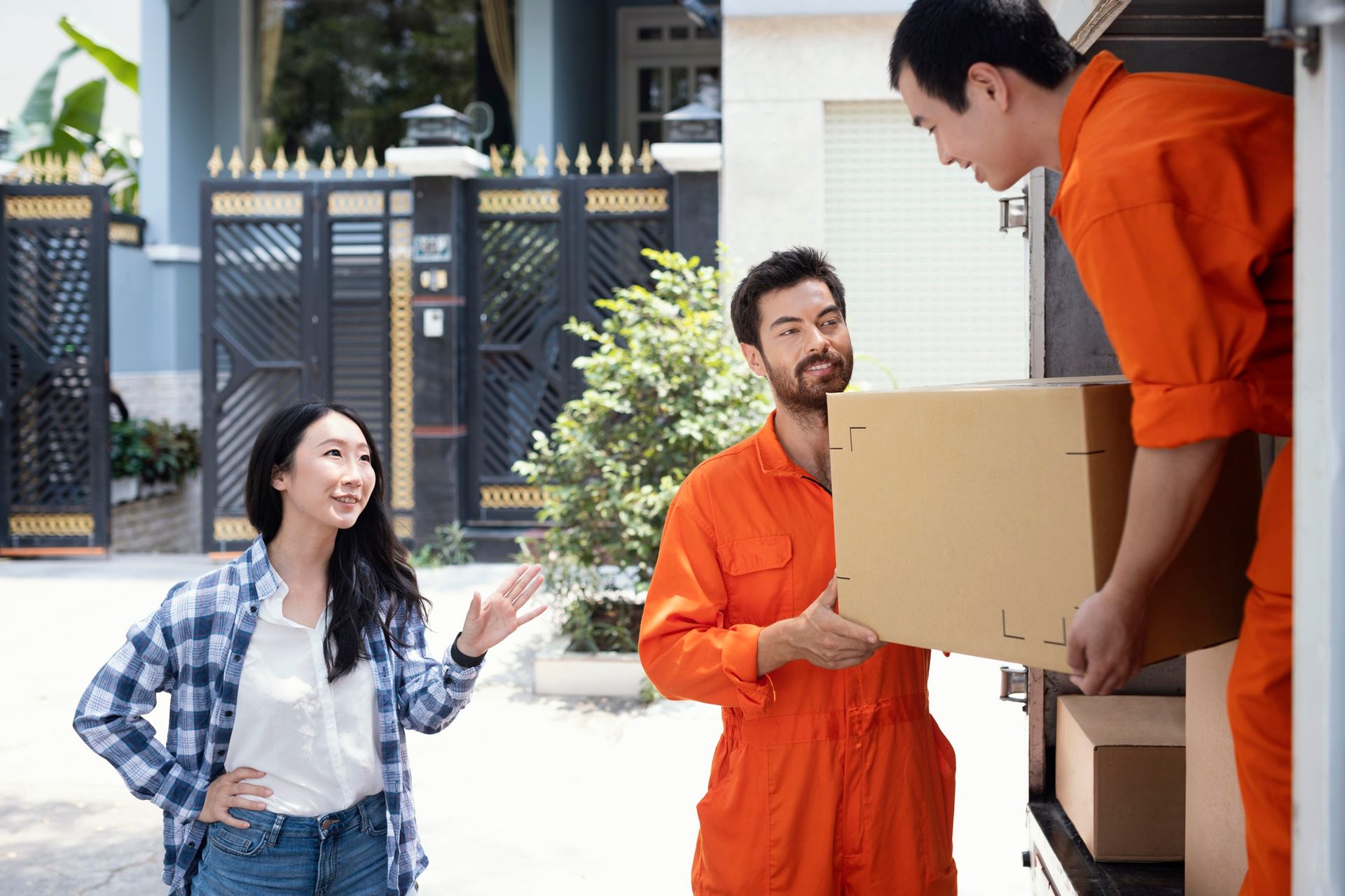 A man is carrying a box to a woman in front of a truck.