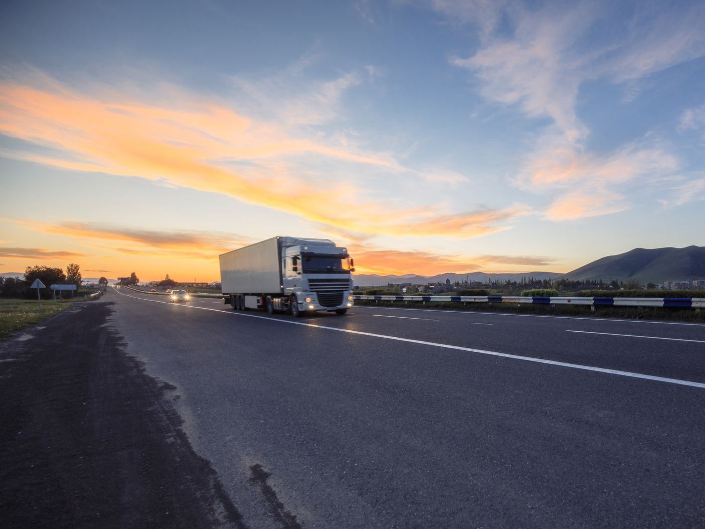 two men are loading boxes into a moving truck .