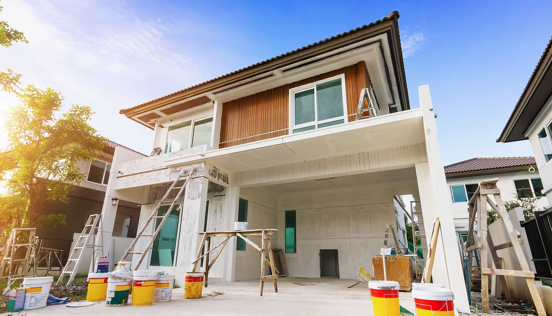House exterior under renovation with scaffolding and paint buckets.