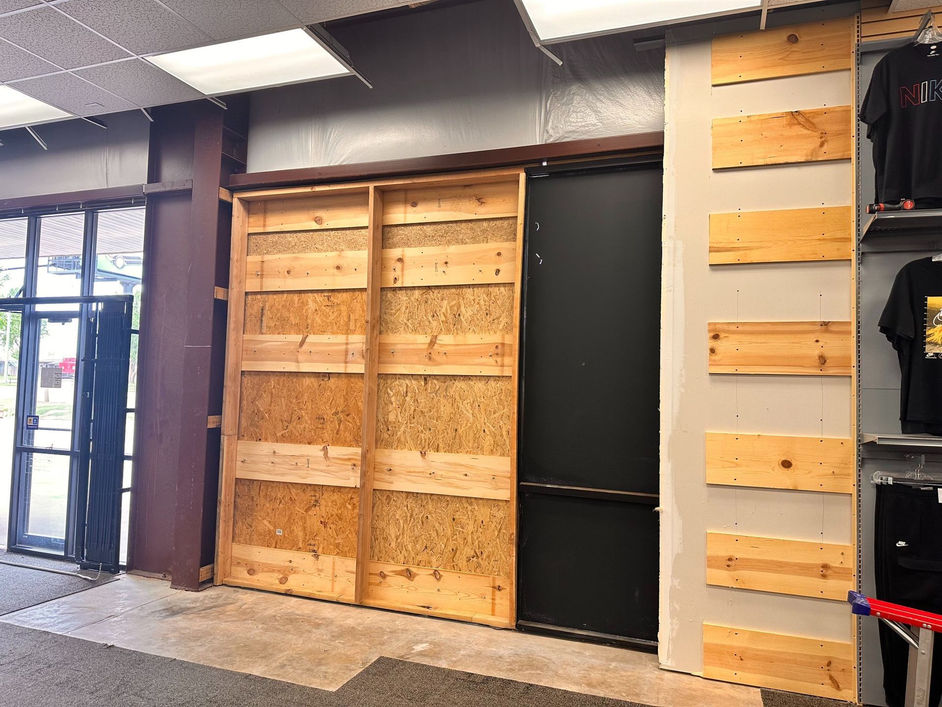 Rustic sliding doors made of wood and particle board cover a black entrance.