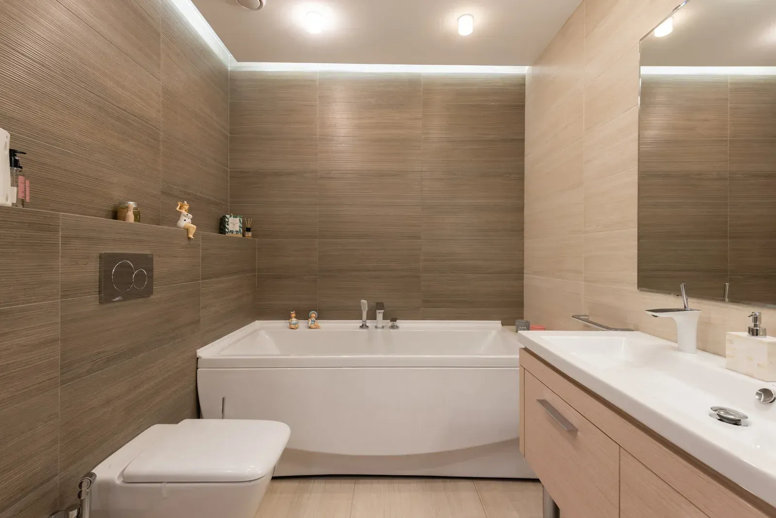 A bathroom with a bathtub , toilet , sink and mirror.