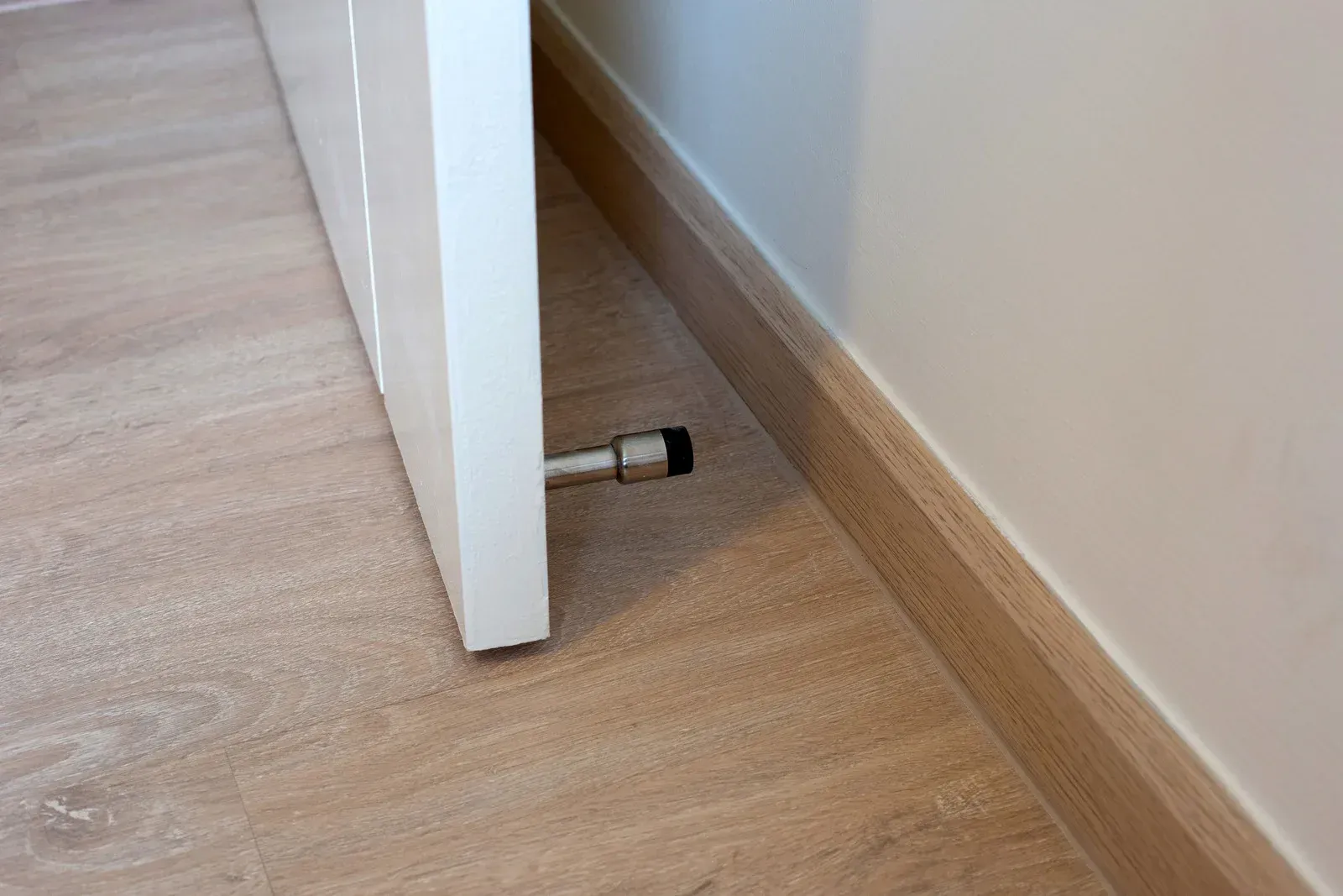 A door stop is sitting on the floor next to a door.
