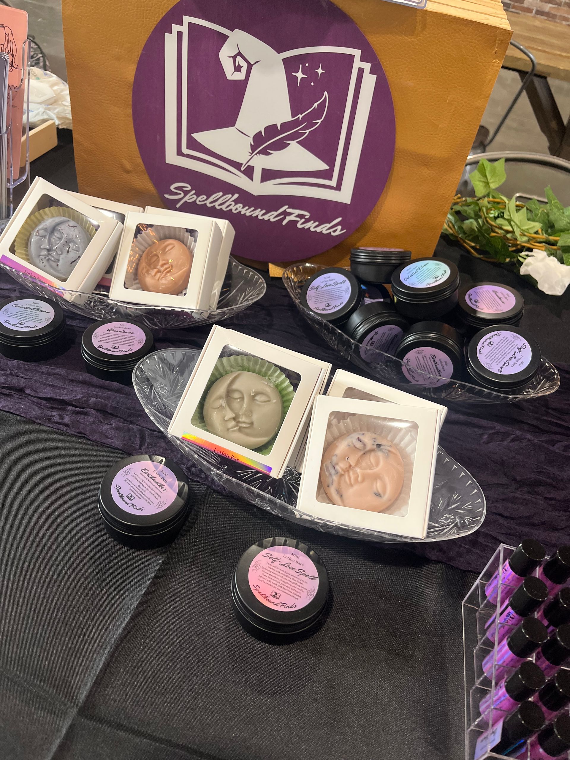 A table topped with a variety of lotion bars and a box with a witch hat on it.