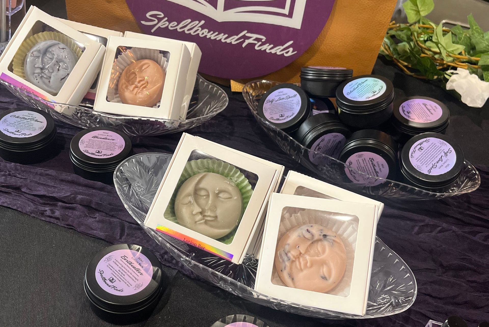 A table topped with a variety of lotion bars and a sign that says spellbound finds