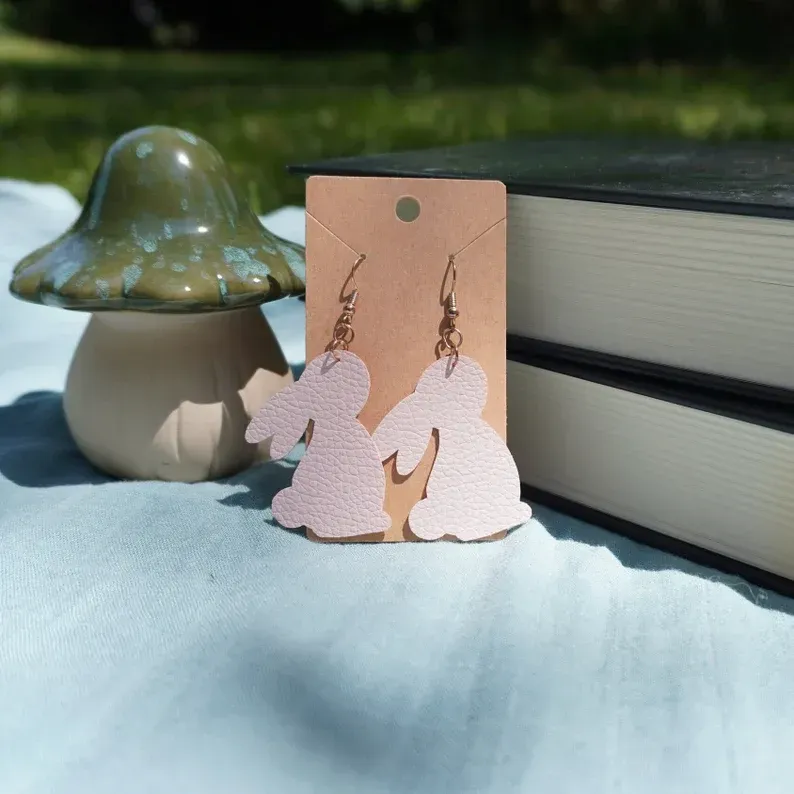 A pair of pink bunny earrings on a card