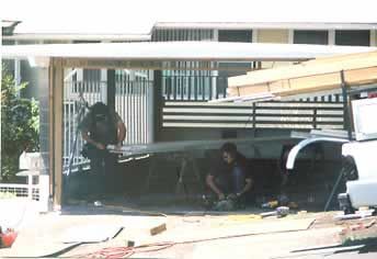 A group of men are working on a garage door.