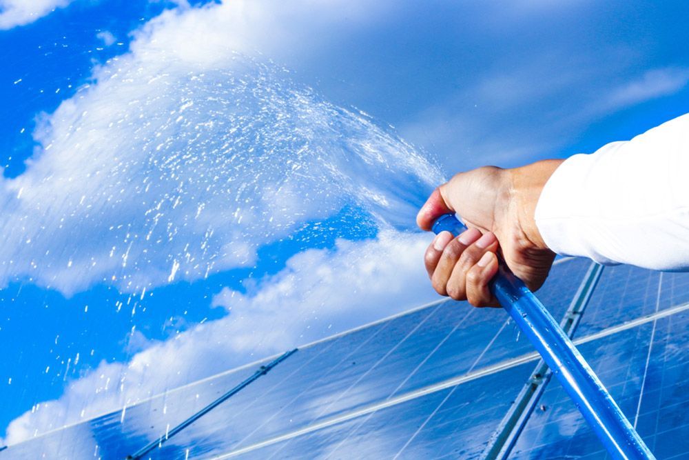 Cleaning the solar panel with water hose — Handyman in Nowra, NSW