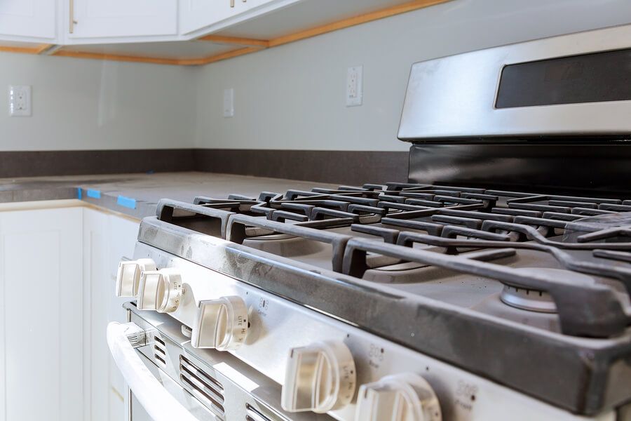 a white stove top oven sitting inside of a kitchen