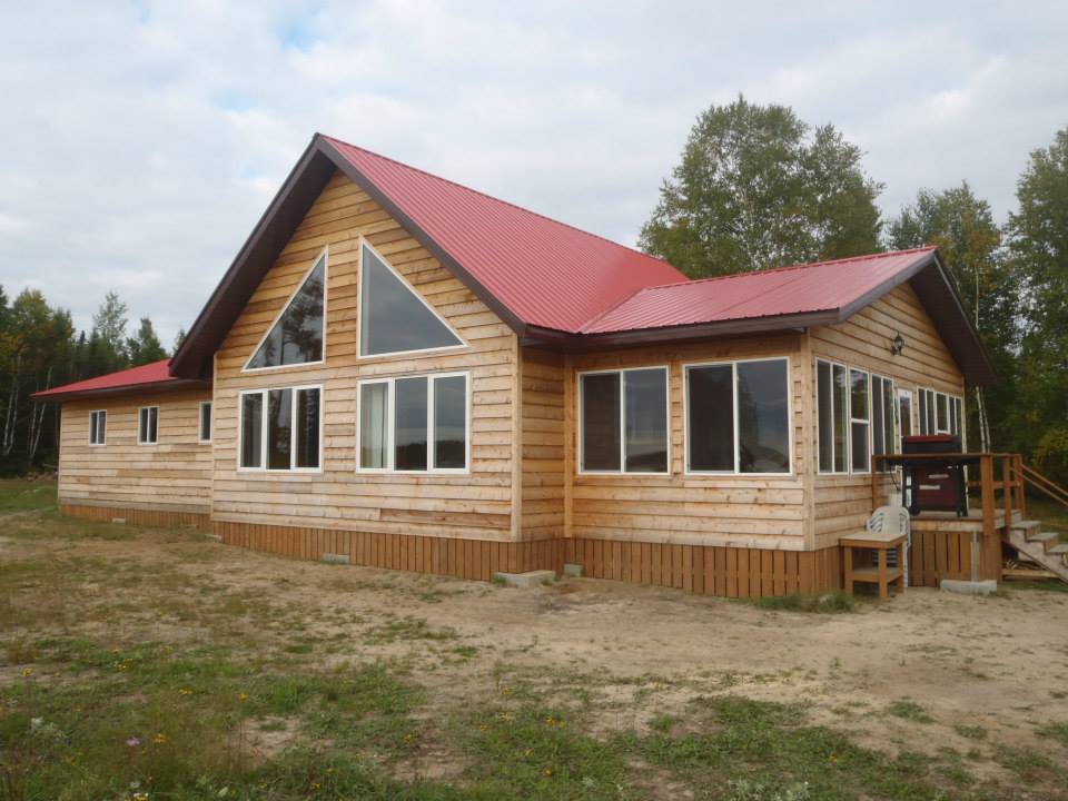 A large wooden house with a red roof
