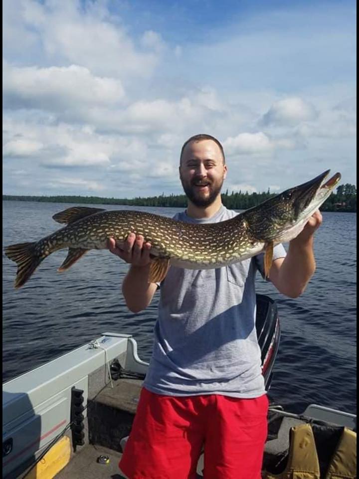 A man is holding a large fish on a boat