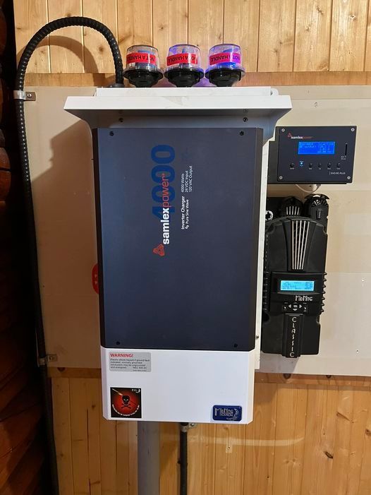 A solar panel inverter is mounted on a wooden wall.