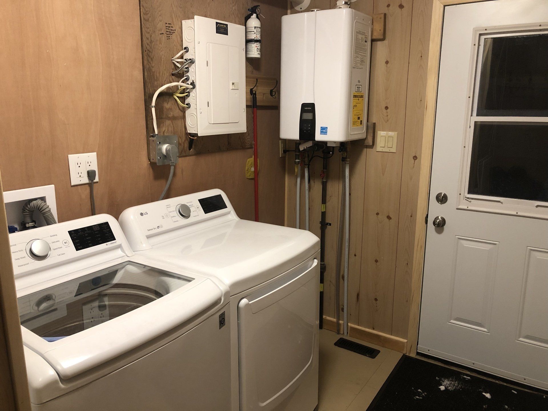 A laundry room with a washer and dryer and a door.