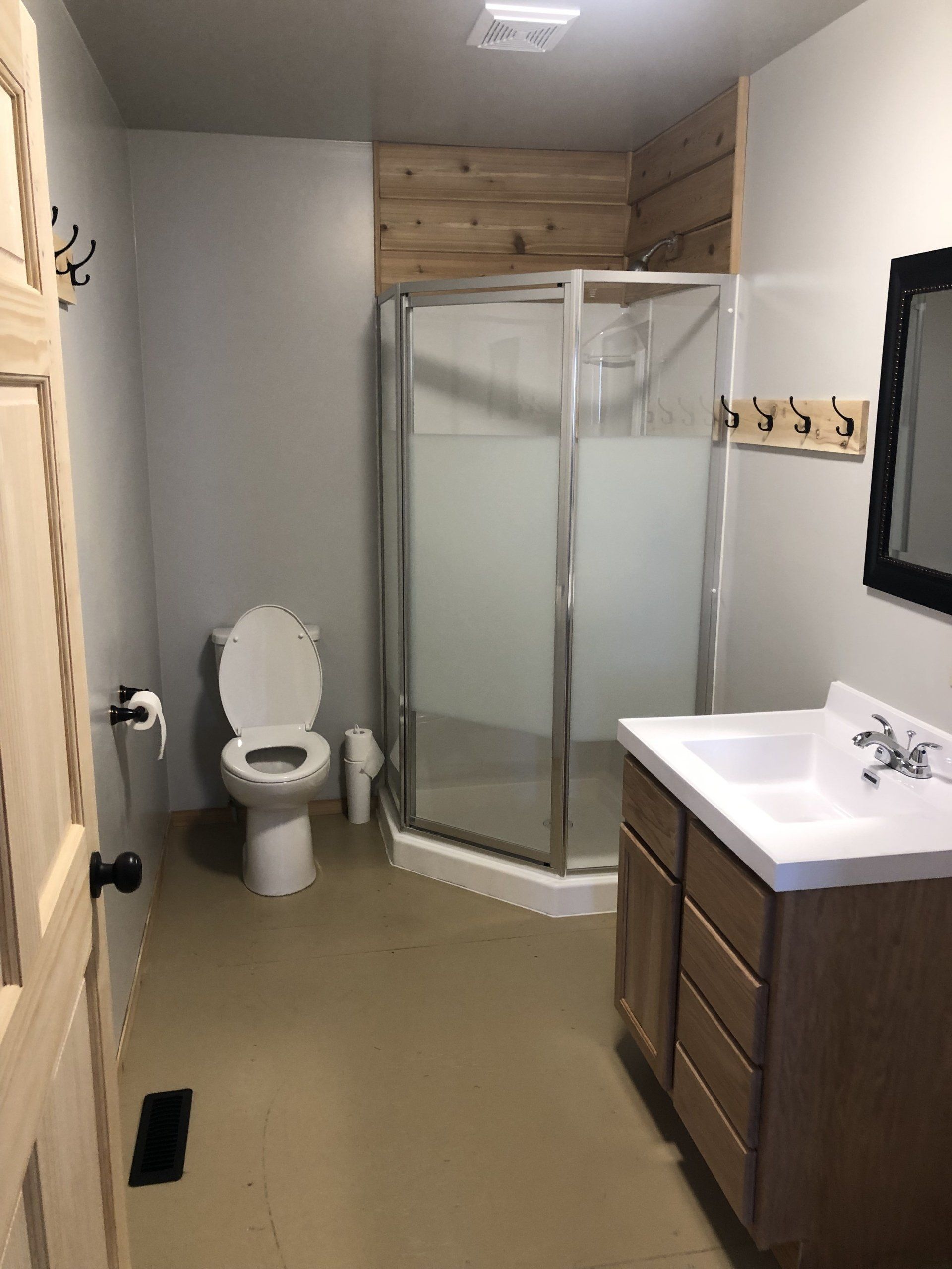 A bathroom with a toilet , sink and shower.