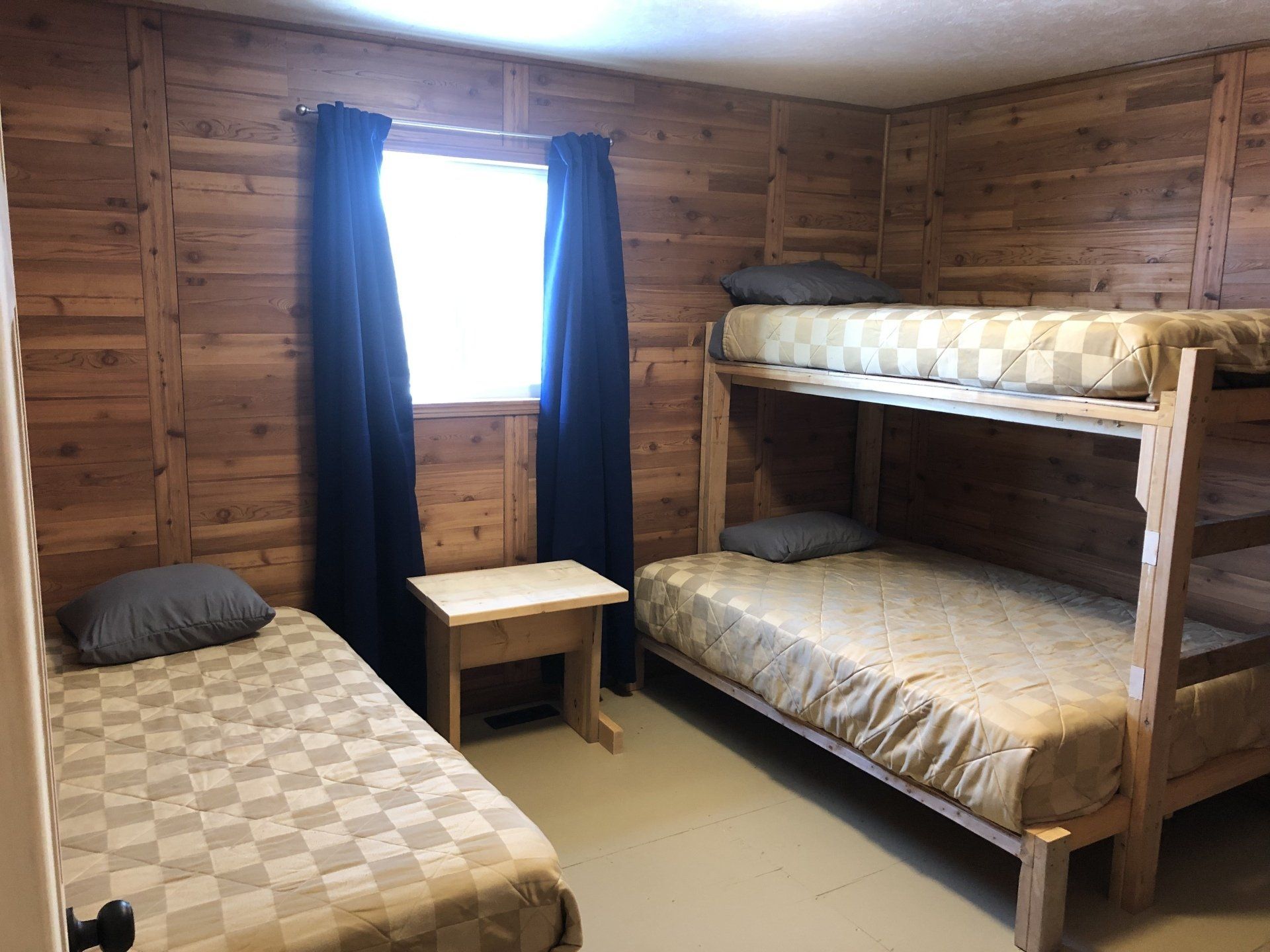 A bedroom with two bunk beds and a window.