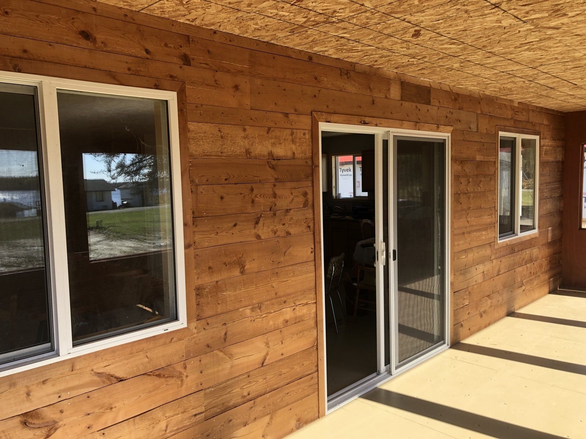 A wooden house with sliding glass doors and windows.