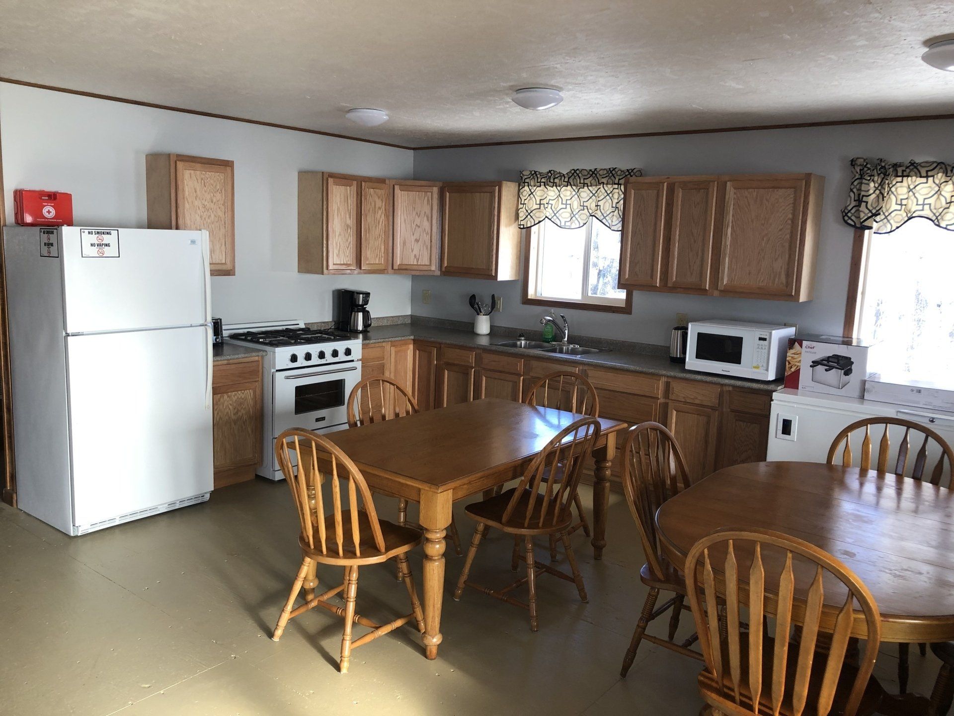 A kitchen with a table and chairs and a refrigerator.