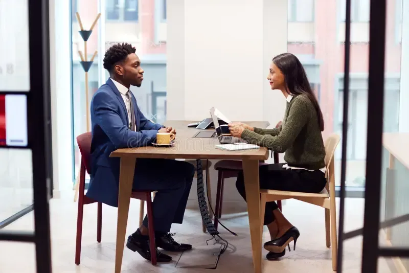 businesswoman interviewing male job candidate meeting room