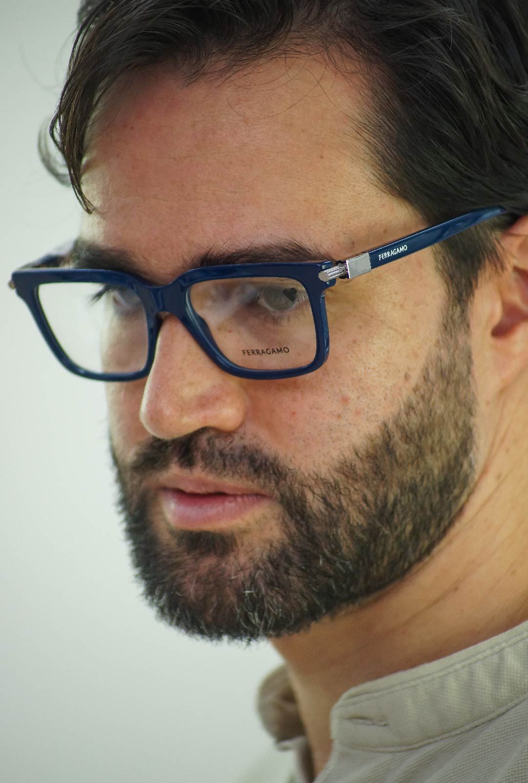 Un hombre con barba y gafas mira a la cámara.