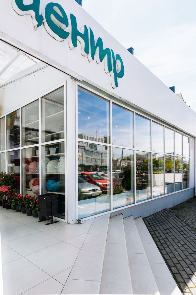 Vista dall'alto di una scalinata di un angolo di un edificio con facciata in vetro e insegna bianca con caratteri cirillici.