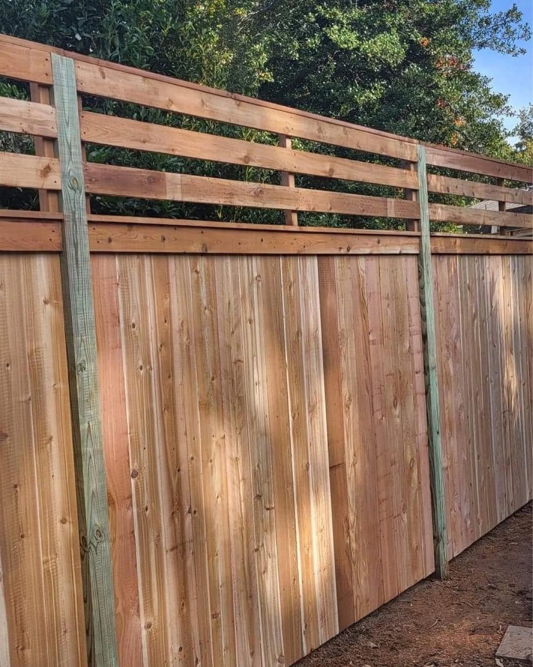 Wooden fence with horizontal slats on top and vertical planks below. Green posts on the side.