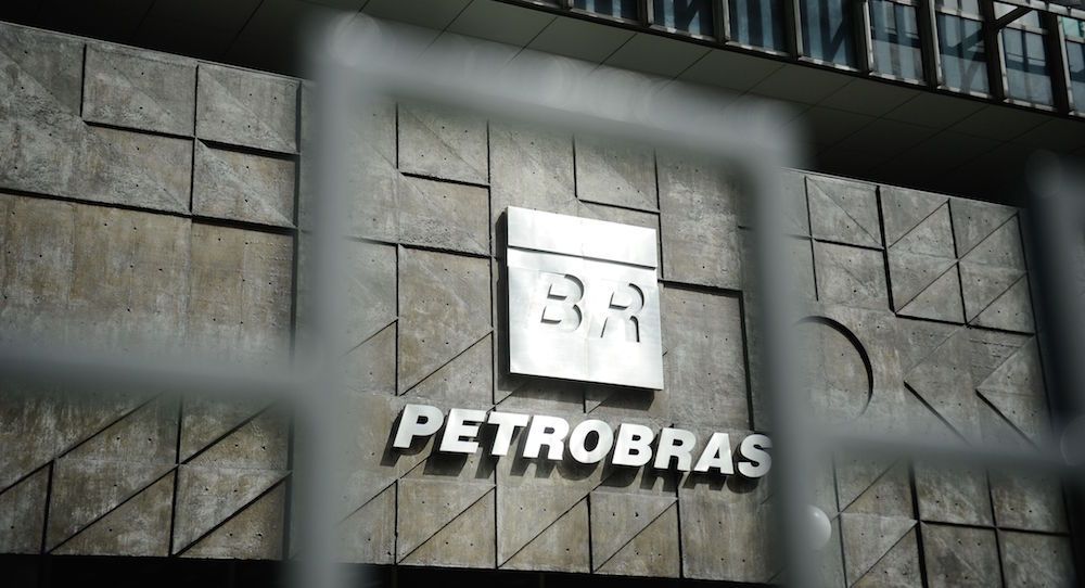 Petrobras logo on a building facade, viewed through a security gate.