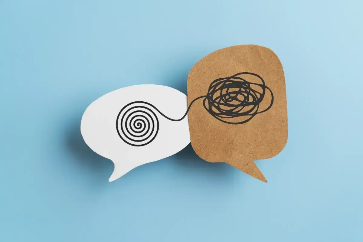 Two speech bubbles connected by a tangled string, representing communication challenges.