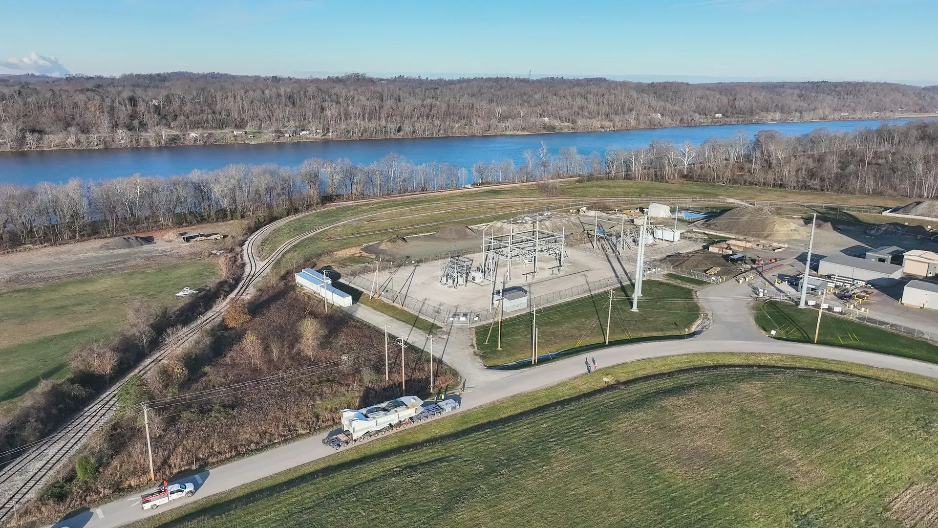 An aerial view of a large body of water surrounded by trees and a road.