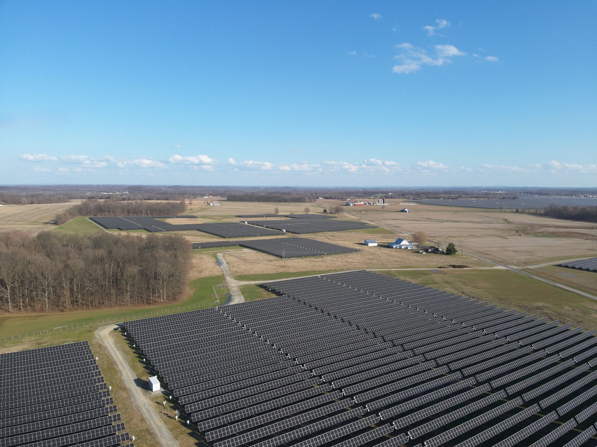 An aerial view of a large solar farm in a field.