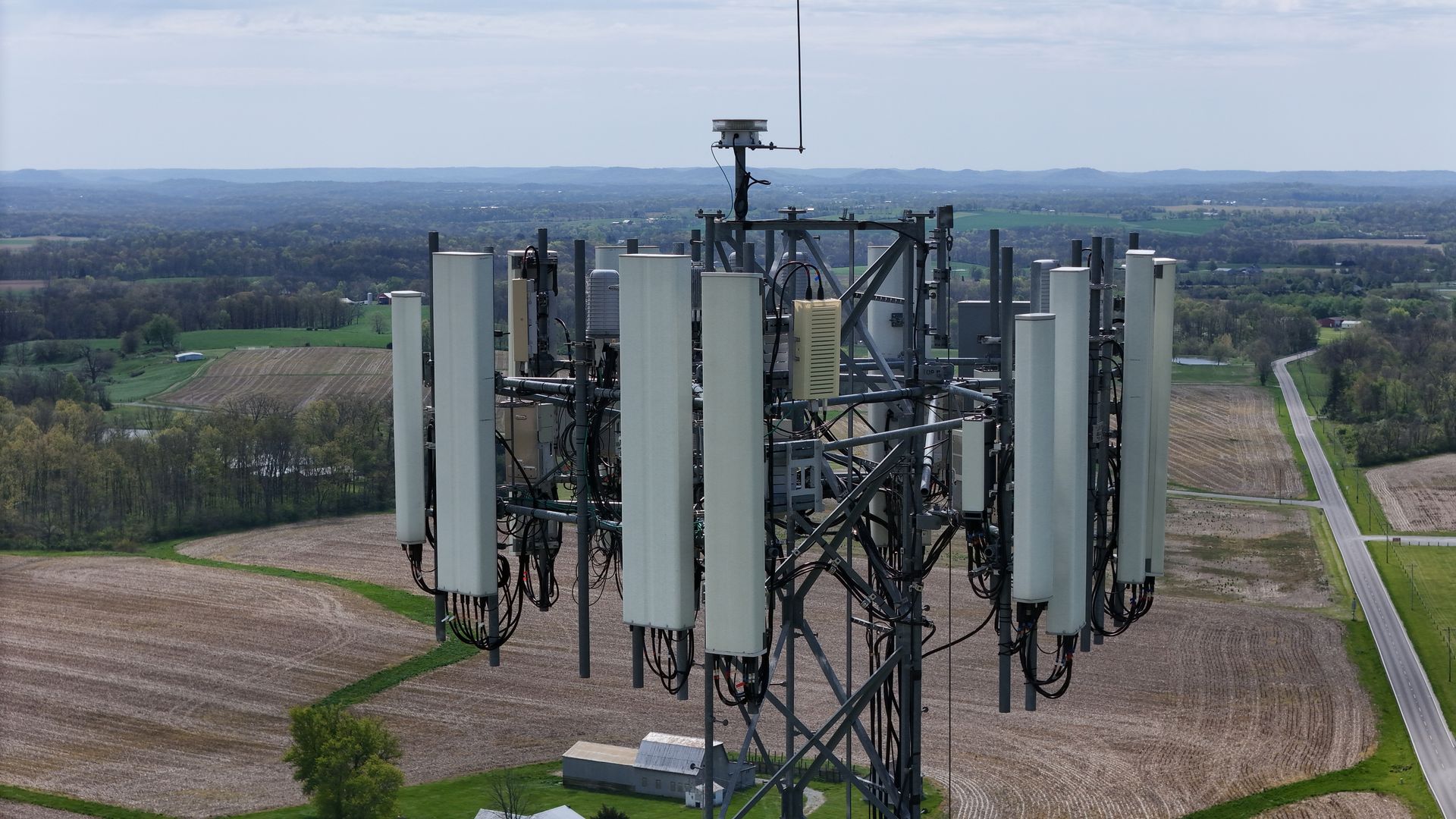 An aerial view of a cell phone tower in a field.