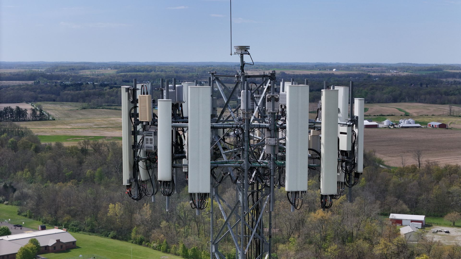An aerial view of a cell phone tower in the middle of a field.