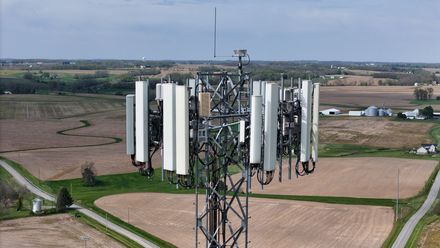 An aerial view of a cell phone tower in a field.