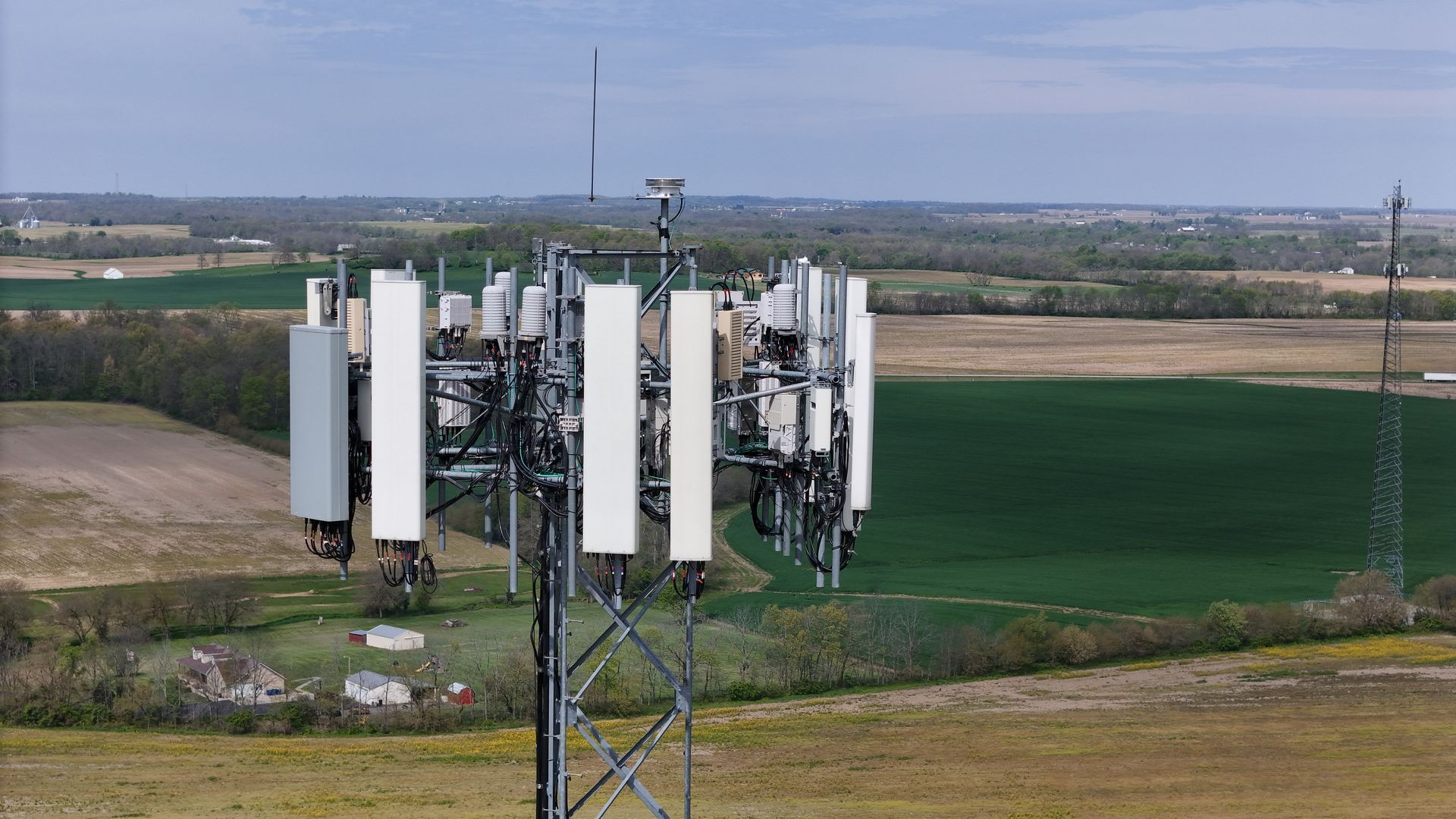 An aerial view of a cell phone tower in the middle of a field.